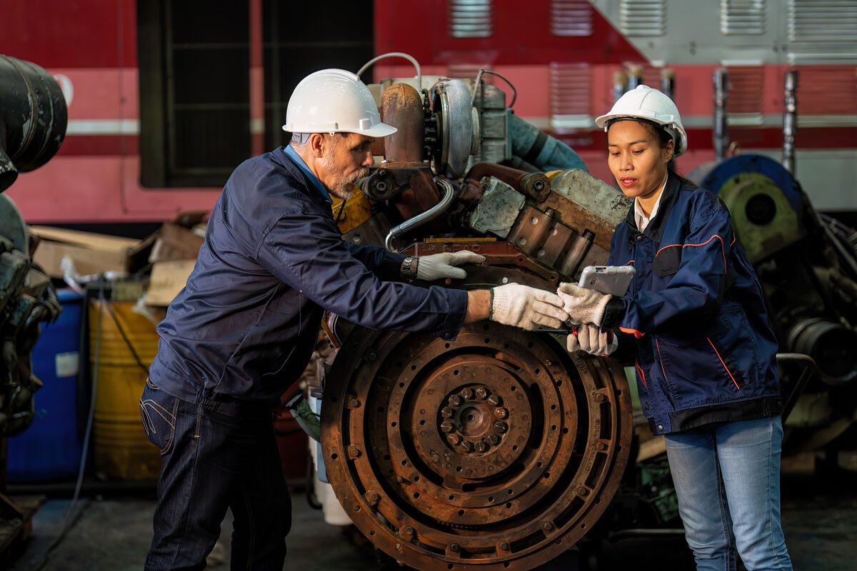 Two technicians inspecting a large engine in a repair shop